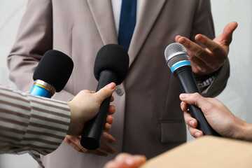 Group of journalists interviewing businessman indoors, closeup