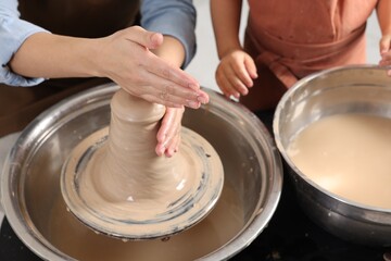 Hobby and craft. Mother with her daughter making pottery indoors, closeup