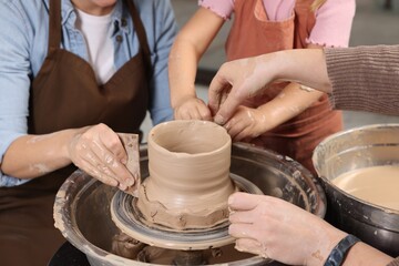 Hobby and craft. Women with girl making pottery indoors, closeup