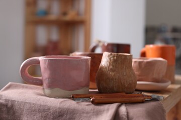 Set of different crafting tools and pottery on shelf indoors, closeup