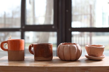 Beautiful pottery on wooden shelf indoors. Space for text