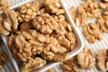 Peeled walnuts in bowl on table, top view