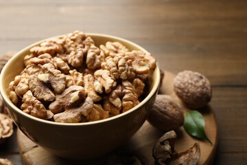 Peeled walnuts in bowl on table, closeup. Space for text