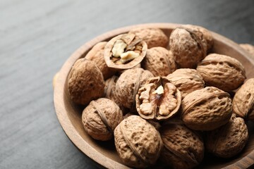 Fresh ripe walnuts in shells on black table, closeup