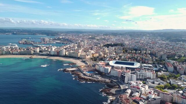 Panoramic aerial view of A Coruna city. View of Riazor Stadium in the middle. Famous travel destination in Galicia, Northwest of Spain. Promenade and beach area of the city. Drone going forward.