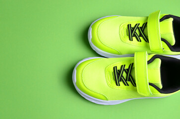 Sports sneakers of light green color on a green background.