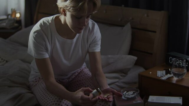 Exhausted woman takes antidepressant with water sip in room