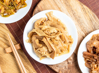braised bamboo shoots served in plate with chopsticks and spoon isolated on wooden board top view of taiwan food