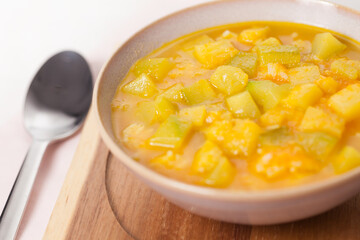 Happiness soup made of zucchini, turmeric and lemon peel in broth.