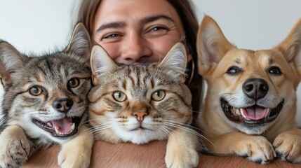 Woman hugging two cats and a dog celebrating national pet day