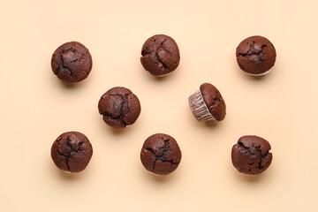 Tasty chocolate cupcakes on beige background