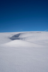 snow drift in alpine area with blue sky with negative space