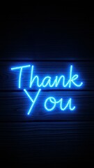 Obraz premium Brightly lit thank you sign glowing in blue against a wooden background at night