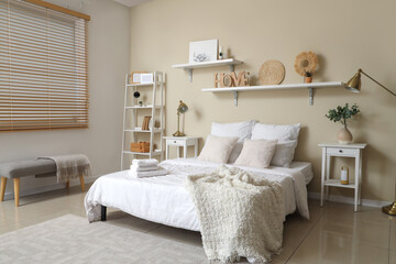 Interior of bedroom with clean towels on bed