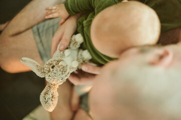 Relax, toy and father with baby at home from top view for cute, cuddle and bonding. Child development, learning and youth with kid and man with stuffed rabbity for happiness, newborn and care