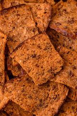 Crispy homemade brown bread chips with seeds and grains