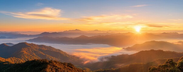 Naklejka premium A breathtaking sunrise illuminates mist-covered mountains, casting a serene glow over the landscape, showcasing nature's beauty.