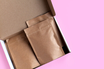 Kraft brown paper empty bags isolated mock up on light pink background. Eco friendly pack with zipper, roasted specialty coffee beans, tea, snack, alternative sample trendy concept. top view, flat lay