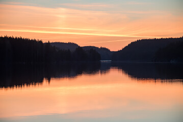 Obraz premium Lake scenery around sunset on a late spring evening in conifer forests of Finland
