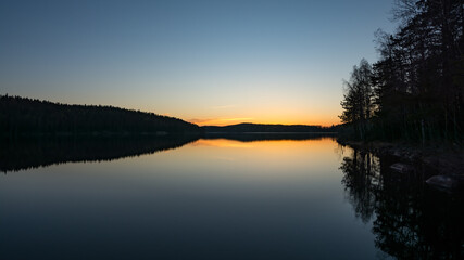 Fototapeta premium Lake scenery around sunset on a late spring evening in conifer forests of Finland