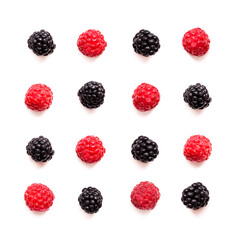 Colorful arrangement of fresh raspberries and blackberries on a white background showcases natural beauty and vibrant hues
