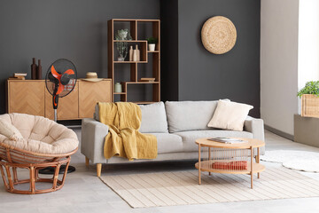 Interior of stylish living room with modern electric fan and grey sofa