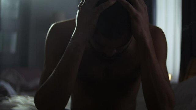 African American man handles emotional struggle in bedroom