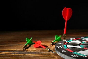 Darts with dartboard on wooden table