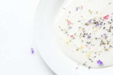 Obraz premium Elegant White Plate with Yogurt Garnished with Edible Flowers and Herbs
