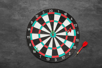 Dartboard with darts on black background