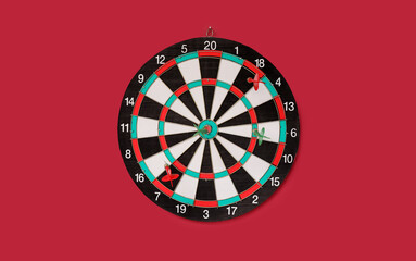 Obraz premium Dartboard with darts hanging on red wall