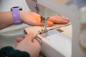 Person beim Säumen von Textilien mit Nähmaschine