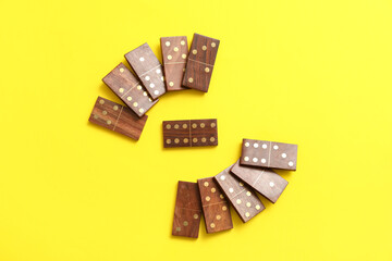 Wooden dominos blocks on yellow background