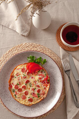 Fried omelette with tomatoes, sausages and fresh herbs for the perfect breakfast