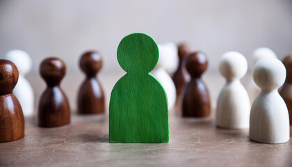 Wooden figurines with one green piece standing out. Uniqueness, leadership or selection.