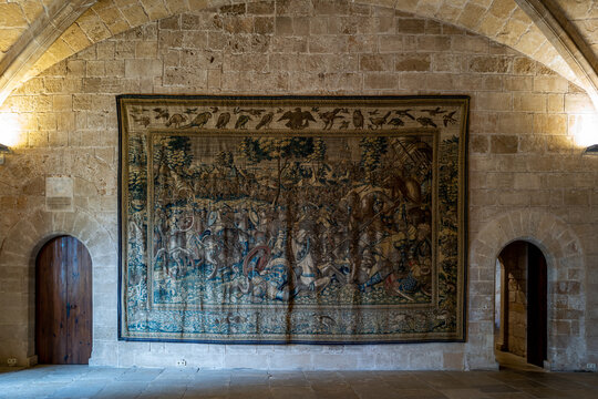 A medieval battle tapestry adorns the stone walls of an ancient hall, creating a captivating historical ambiance.