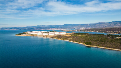 Fototapeta premium Spectacular aerial drone shot of the LNG (liquefied natural gas) terminal on Krk Island, Croatia, featuring a massive gas tanker docked at the facility