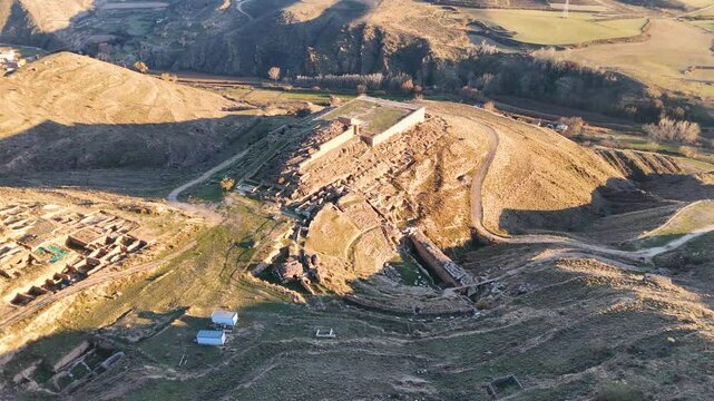 Aerial view of an ancient archaeological site of Augusta Bilbilis in northern Spain with ruins and structures on a hilly landscape.