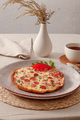 Fried omelette with tomatoes, sausages and fresh herbs for the perfect breakfast