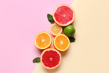 Different cut citrus fruits with mint leaves on color background