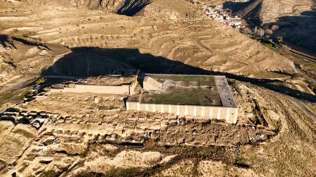 Aerial view of an ancient archaeological site of Augusta Bilbilis in northern Spain with ruins and structures on a hilly landscape.