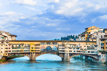 The Ponte Vecchio, Old Bridge, a Medieval stone closed-spandrel segmental arch bridge over the Arno...