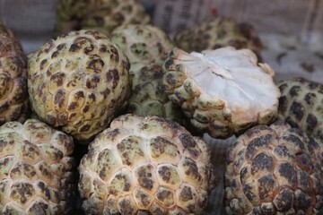 Close up  of stack of custard apples (sugar apples or Annona squamosa), lying on newspaper at a stall in Kathmandu