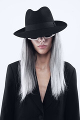 Fashion beautiful young woman with bleached long hair wearing sunglasses, black hat and black jacket, isolated on white background. For a magazine cover, advertising poster and web or shop banner