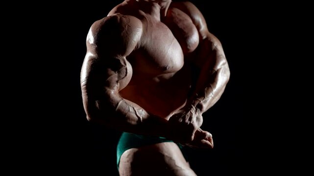 The athlete stands in the classic bodybuilding pose, demonstrating strength and control over his body.