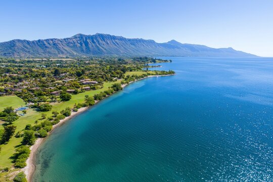 An expansive aerial view of Maconde Bay, showcasing a scenic viewpoint and a mountain range behind, Maconde, Mauritius.