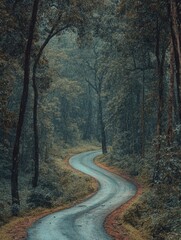 Fototapeta premium A curvy, unpaved forest path surrounded by lush greenery and towering trees.