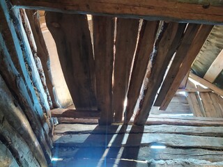 Interior of an old wooden barn with a beam of light.