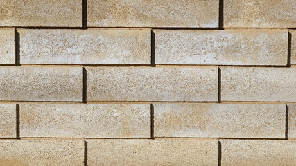 Beige inclined rectangular porous concrete blocks exterior wall texture. Fawn cement bricks for construction, house walls, facade, enclosure, division of plots.