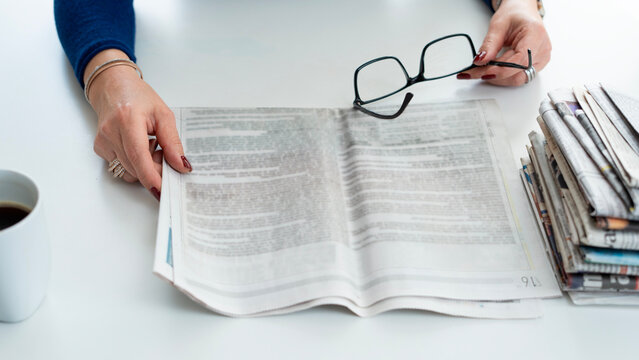 woman reading newspaper at office